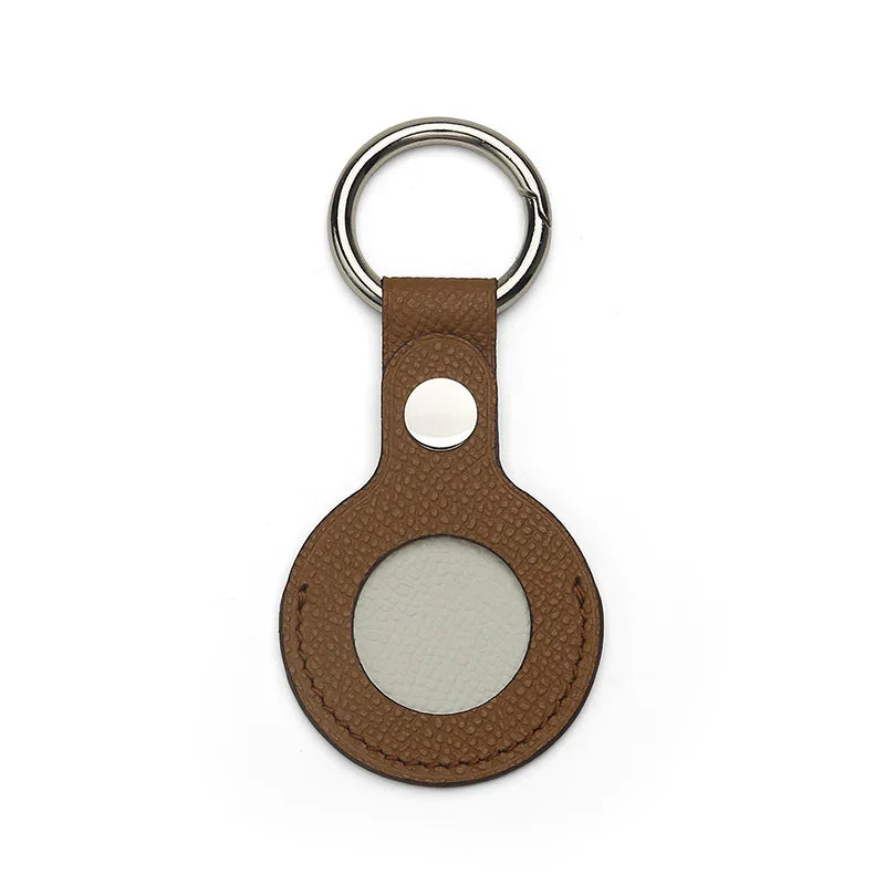 Brown leather airtag cover with a silver ring on a white background