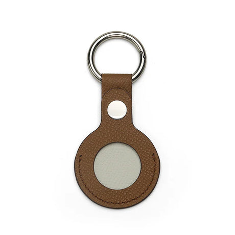 Brown leather airtag cover with a silver ring on a white background