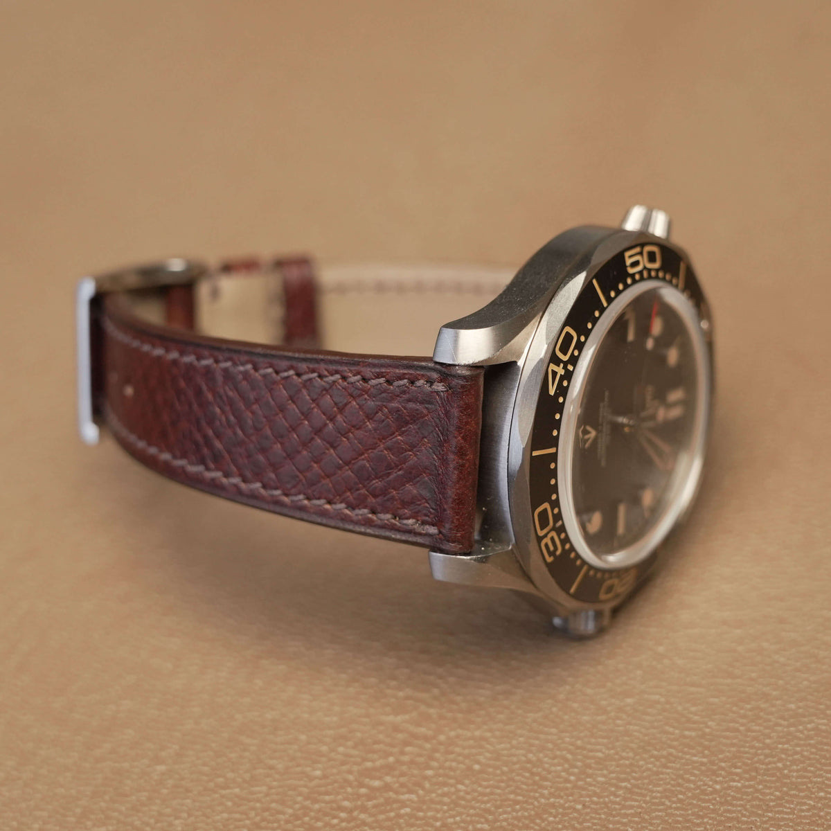 Side profile of 1.8mm flat brown Italian leather watch strap fitted on titanium dive watch case