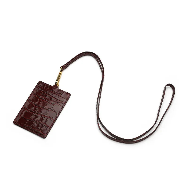 burgundy leather ID holder with a strap on a white background