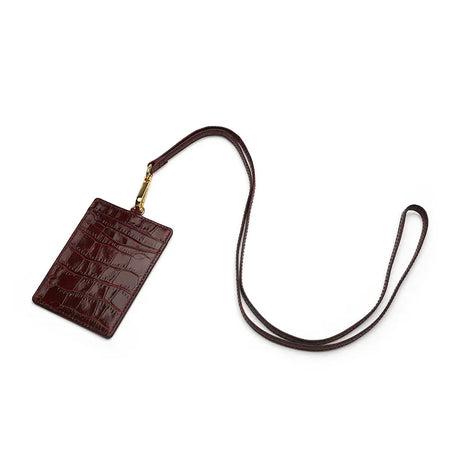 burgundy leather ID holder with a strap on a white background