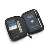 Black passport wallet with a German passport, cards, and a pen on a white background