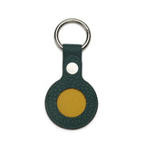 Green leather airtag holder and yellow round keychain with a silver ring on a white background