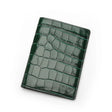 Green crocodile patterned leather passport wallet on a white background