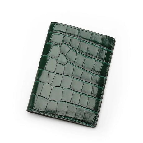 Green crocodile patterned leather passport wallet on a white background
