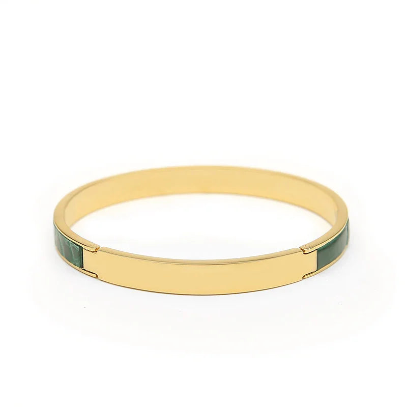Gold bangle bracelet with green stone inlay, minimalist luxury accessory