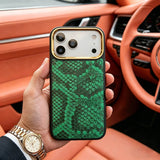 Hand holding an iphone with a premium green snake skin case in a luxury car interior