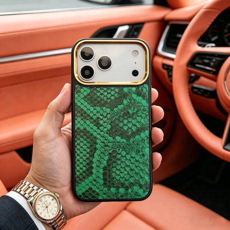 Hand holding an iphone with a premium green snake skin case in a luxury car interior