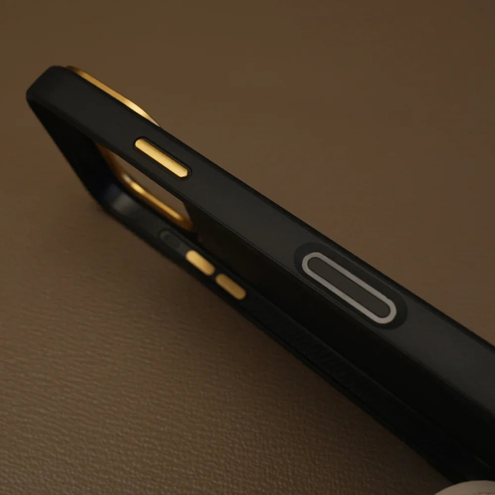 Close-up of a black phone case with gold accents on a brown textured surface