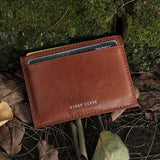Brown leather card case with 'HIRAM BERON' branding on a natural background
