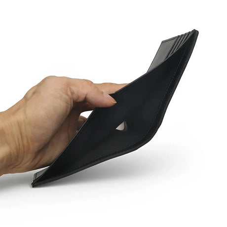 Hand holding an empty black saffiano leather wallet on a white background