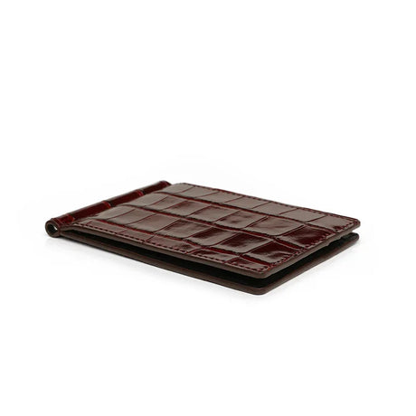 Close-up of the edge for burgundy crocodile pattern money clip wallet on a white background