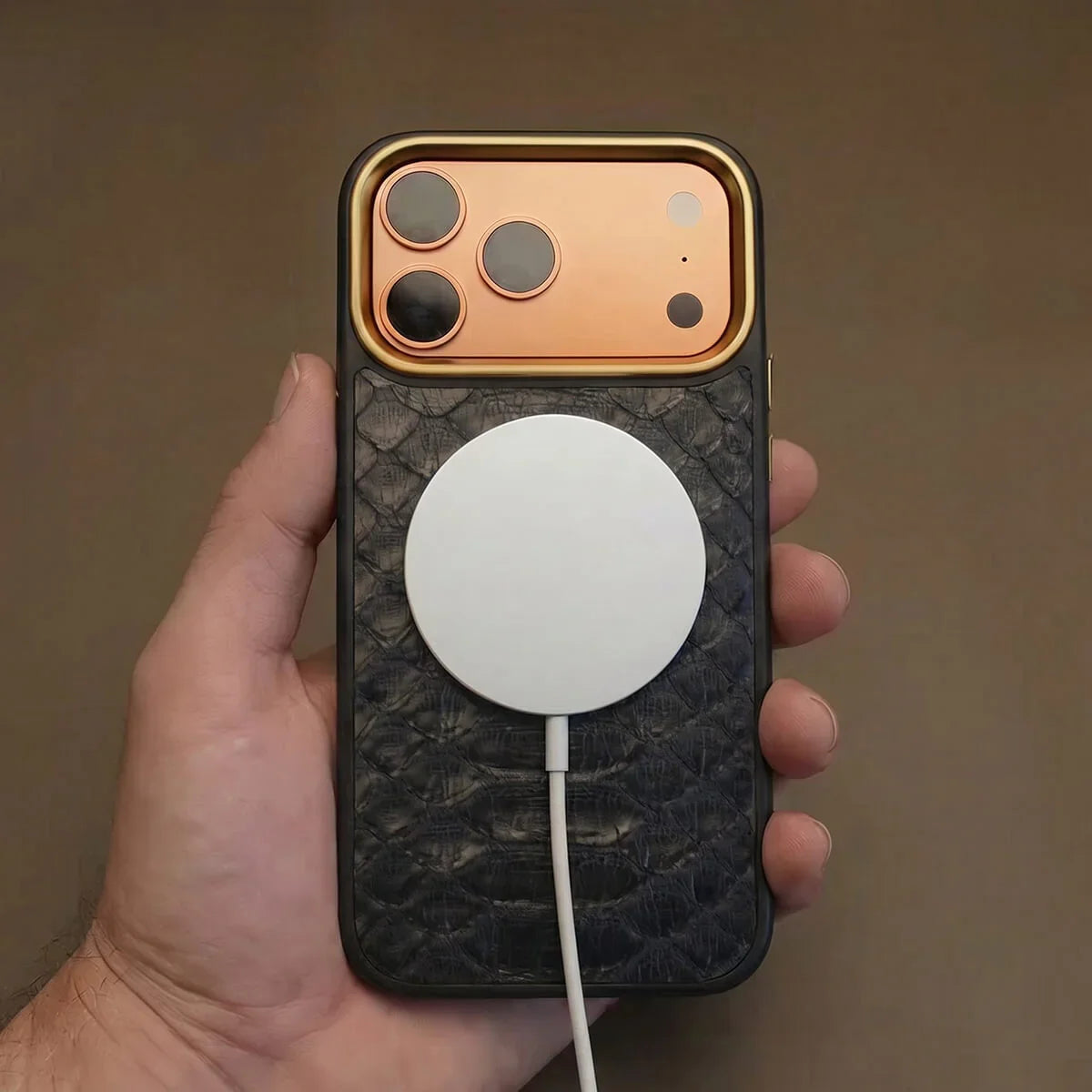 iPhone 17 pro case with a magsafe charging held by a hand against a brown background