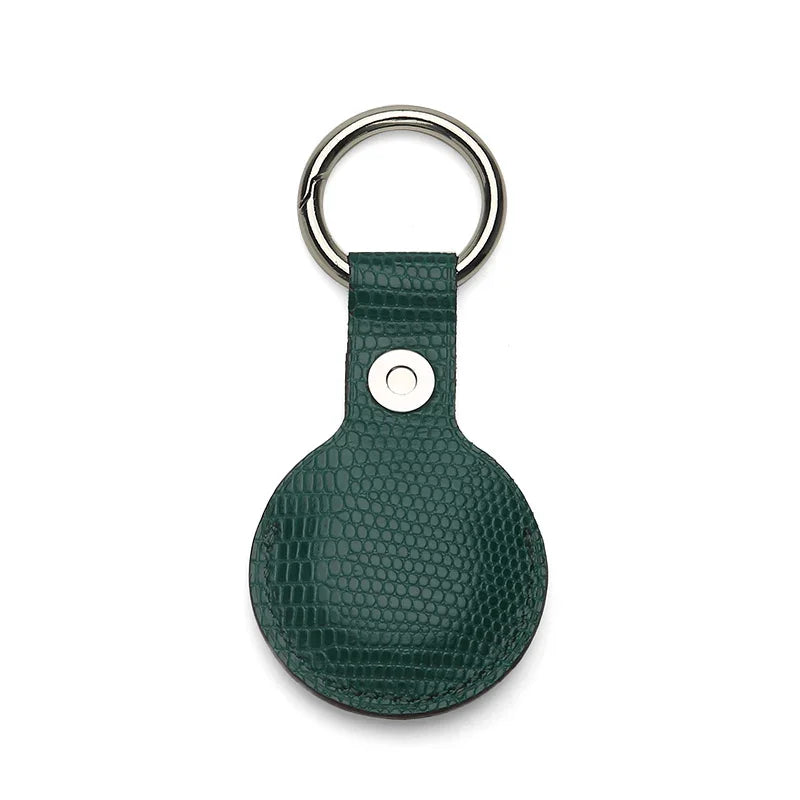 Green leather airtag cover with metallic ring on a white background
