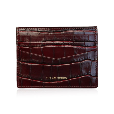 Burgundy crocodile-patterned cardholder with 'Hiram Beron' branding on a white background
