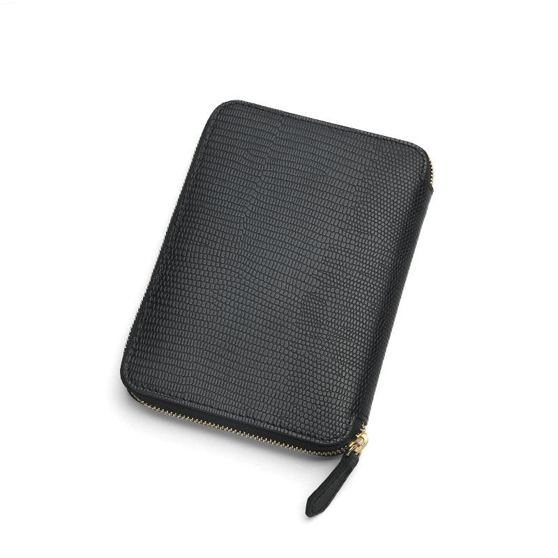 Black lizard pattern leather passport wallet on a white background