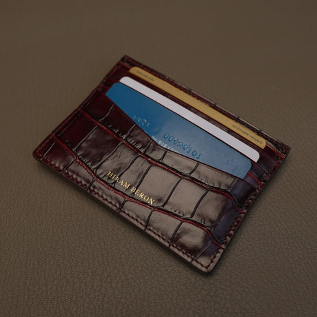 burgundy leather cardholder with cards on a brown background