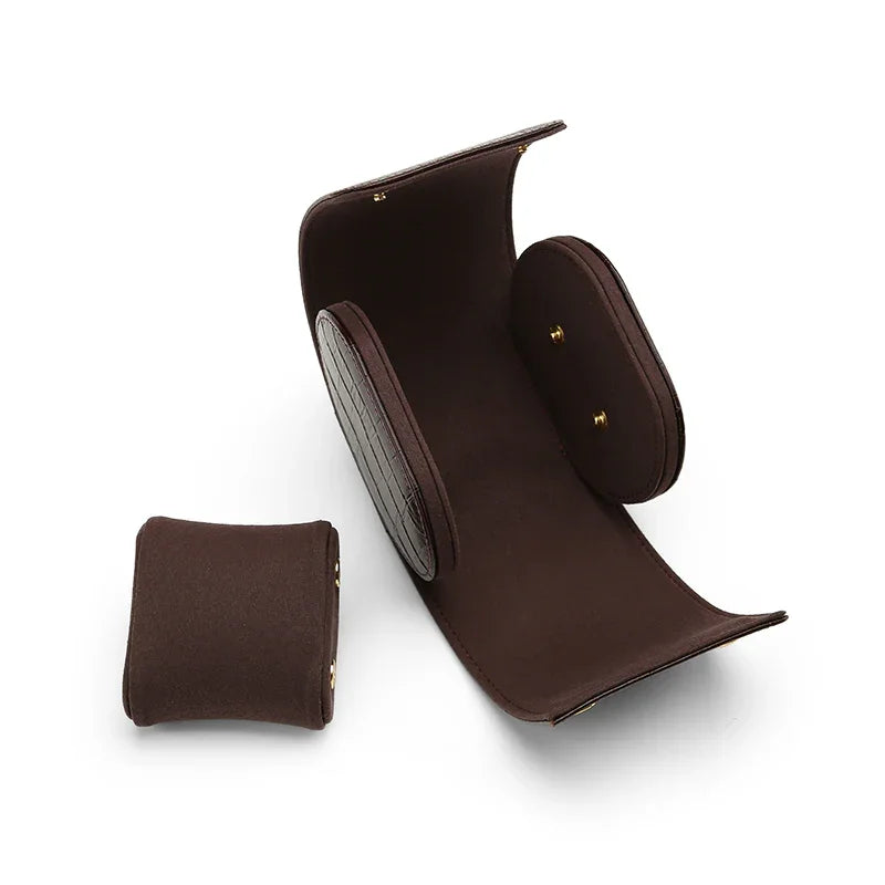 Handcrafted opened aligator pattern leather travel watch roll case with internal suede pillow and gold snaps.