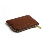 Brown leather coin pouch with a gold zipper on a white background
