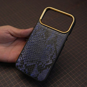 Hand holding a phone case with genuine python skin on a grid background