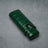 Emerald green croc-embossed leather cigar case with strap closure on textured gray surface