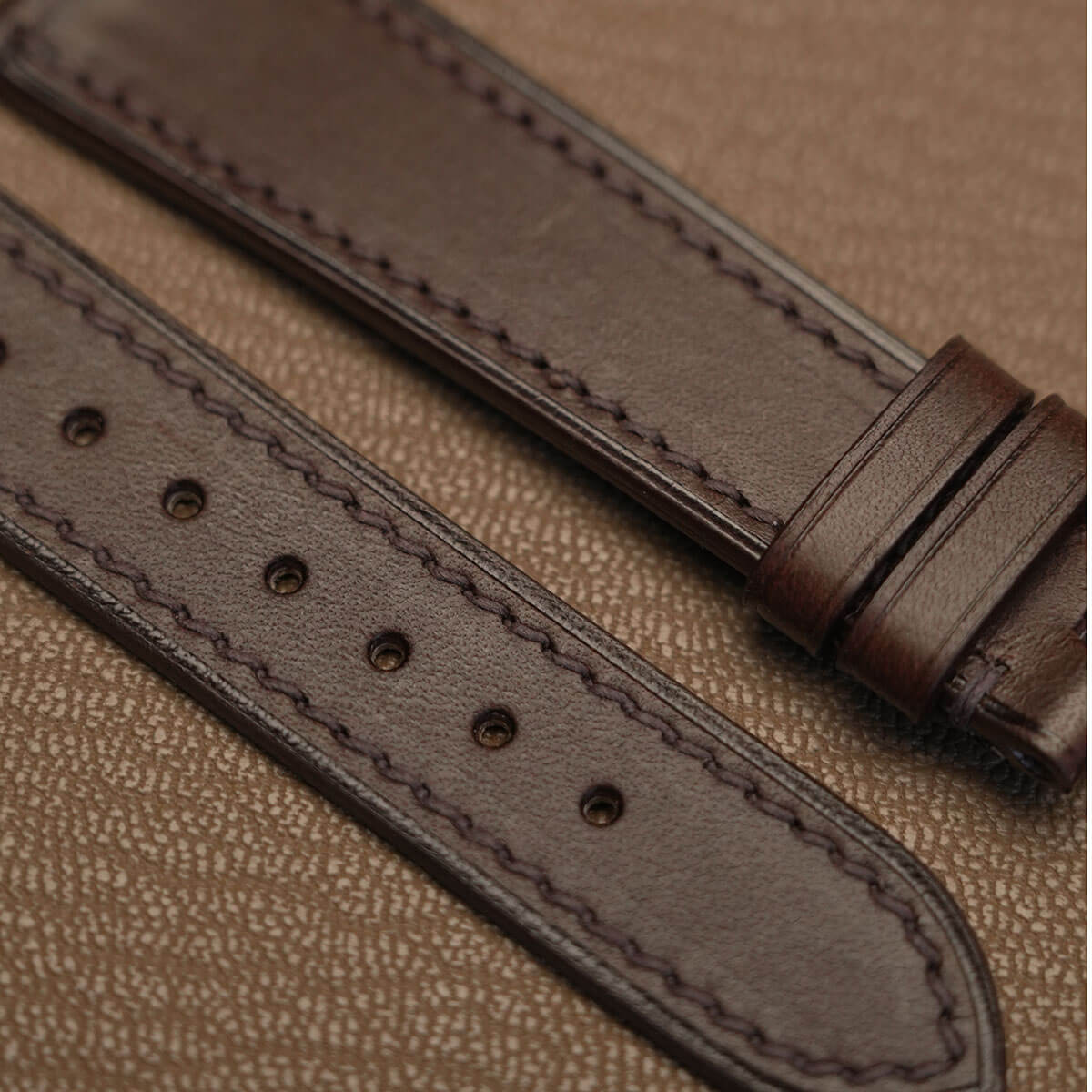 Macro texture of Italian Badalassi Minerva Liscio smooth leather watch band showing precision machine stitching   