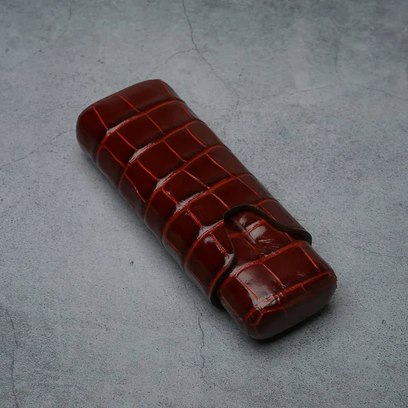 Luxury crocodile-embossed leather cigar case with secure strap, ideal for premium tobacco accessories.