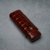 Luxury crocodile-embossed leather cigar case with secure strap, ideal for premium tobacco accessories.