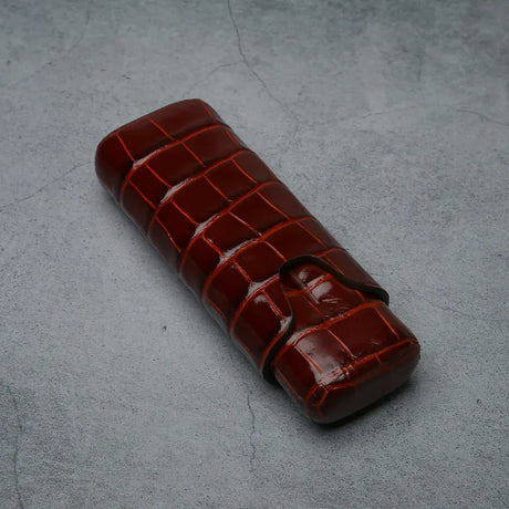 Luxury crocodile-embossed leather cigar case with secure strap, ideal for premium tobacco accessories.