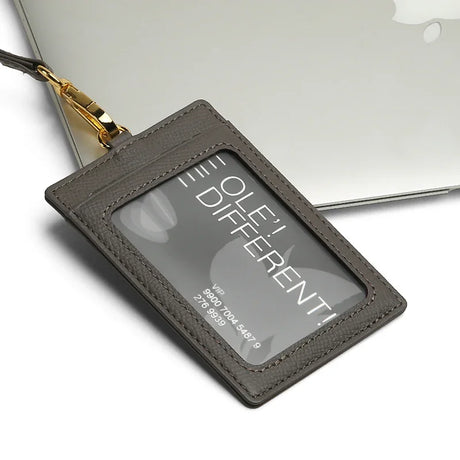 Gray badge holder with 'OLE' DIFFERENT' text on a white background