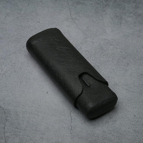 Black textured leather eyeglass case on concrete surface, luxury accessory for men