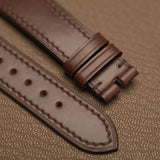 Macro texture of genuine Horween Chromexcel pull-up leather watch strap showing clean machine stitch