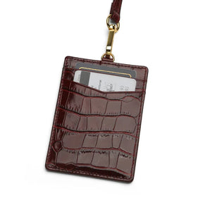 burgundy crocodile pattern ID badge holder with a strap on a white background