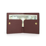 burgundy leather wallet with gold buttons holding a banknote on a white background