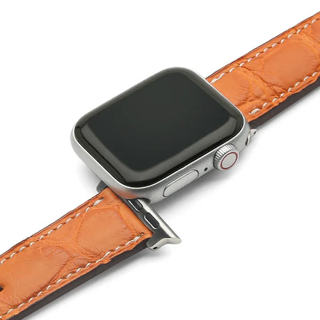Smartwatch with an orange crocodike skin watch strap on a white background
