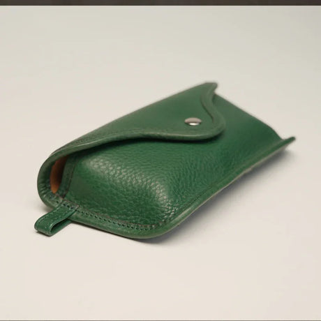 detail of the green leather glasses pouch in white background