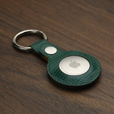 Green leather keychain holder on a wooden surface