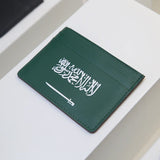 Green cardholder with white flag design on a white surface