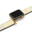 Smartwatch with a beige and gold lizard skin strap on a white background