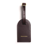 coffee brown leather luggage tag with a gold buckle on a white background