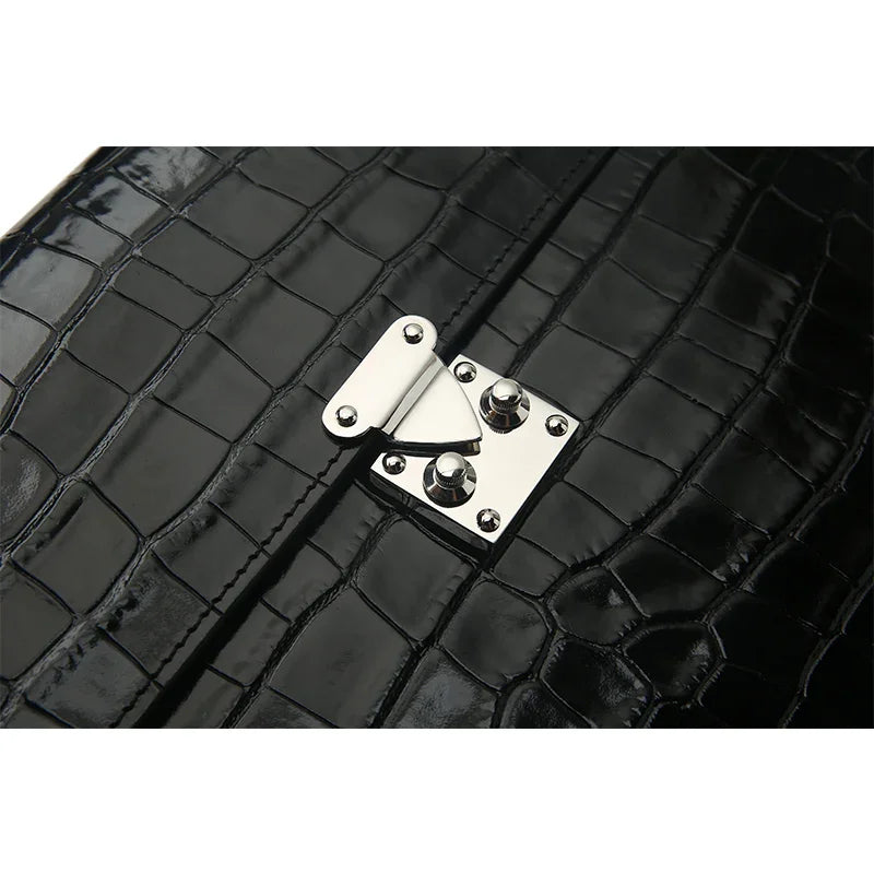 Close-up of a black crocodile-patterned leather bag with a silver clasp.