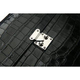Close-up of a black crocodile-patterned leather bag with a silver clasp.