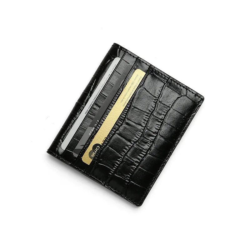 Black aligator-patterned wallet with a card and pen on a white background