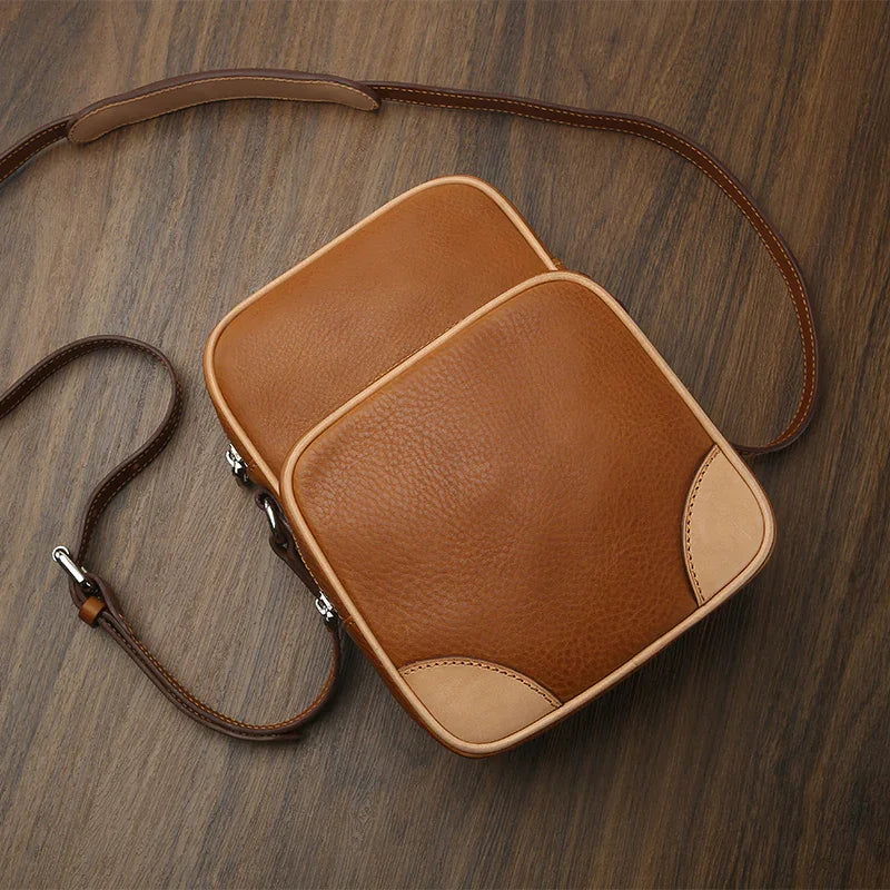 Brown leather reporter bag on a wooden surface