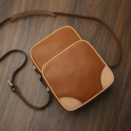 Brown leather reporter bag on a wooden surface