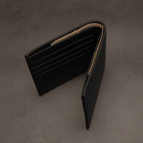 Black leather wallet on a gray background