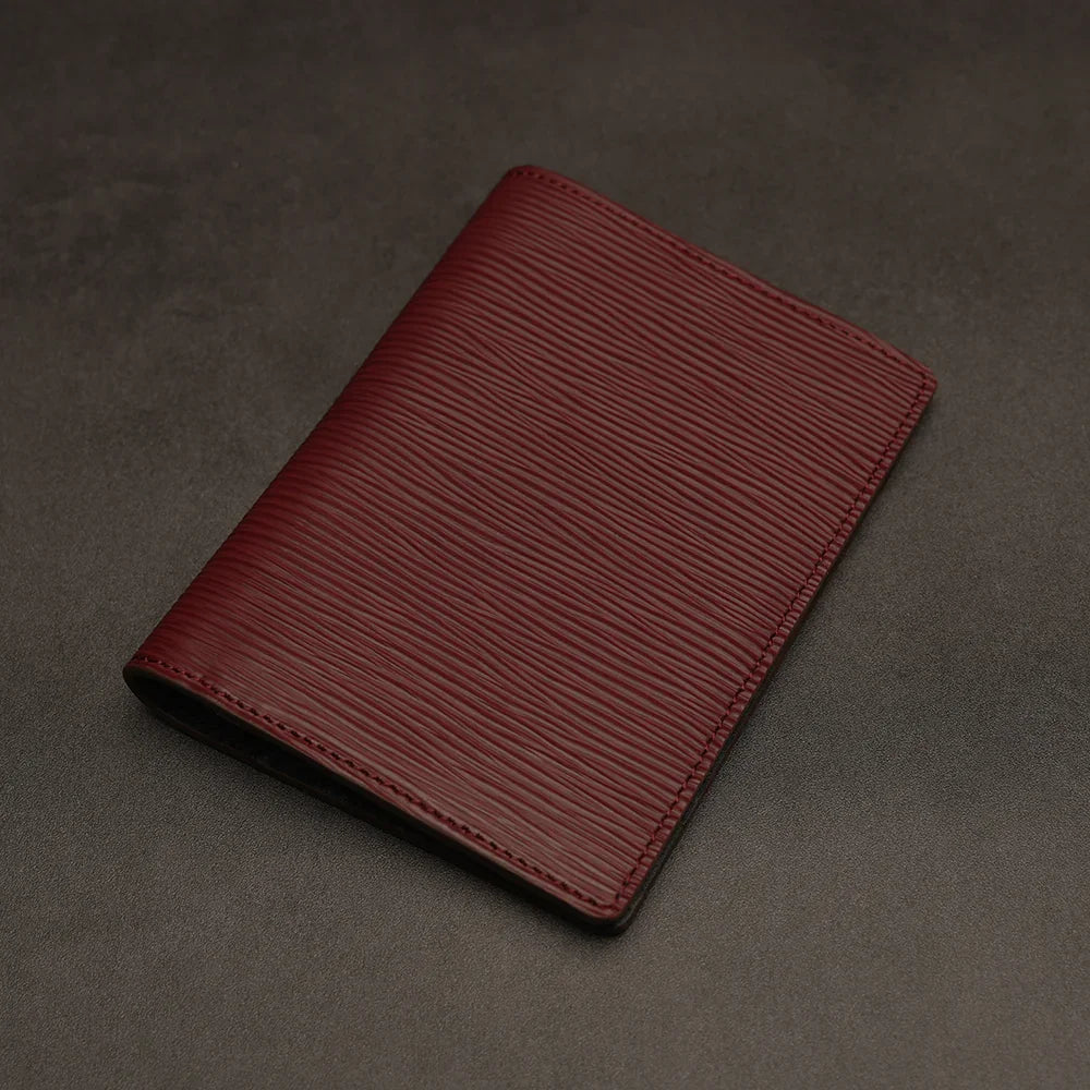 Red leather passport holder on a dark grey background
