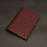 Red leather passport holder on a dark grey background