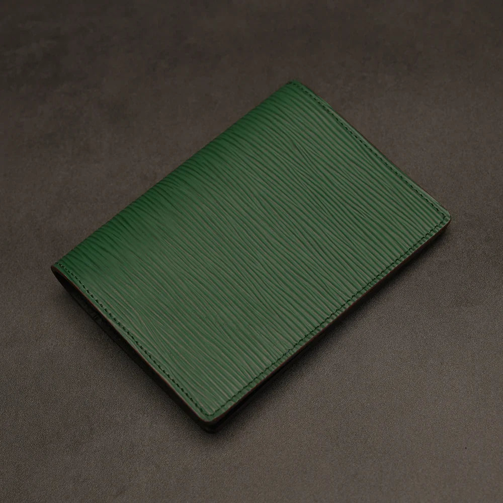 Green passport holder on a dark gray background