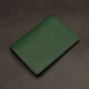 Green passport holder on a dark gray background